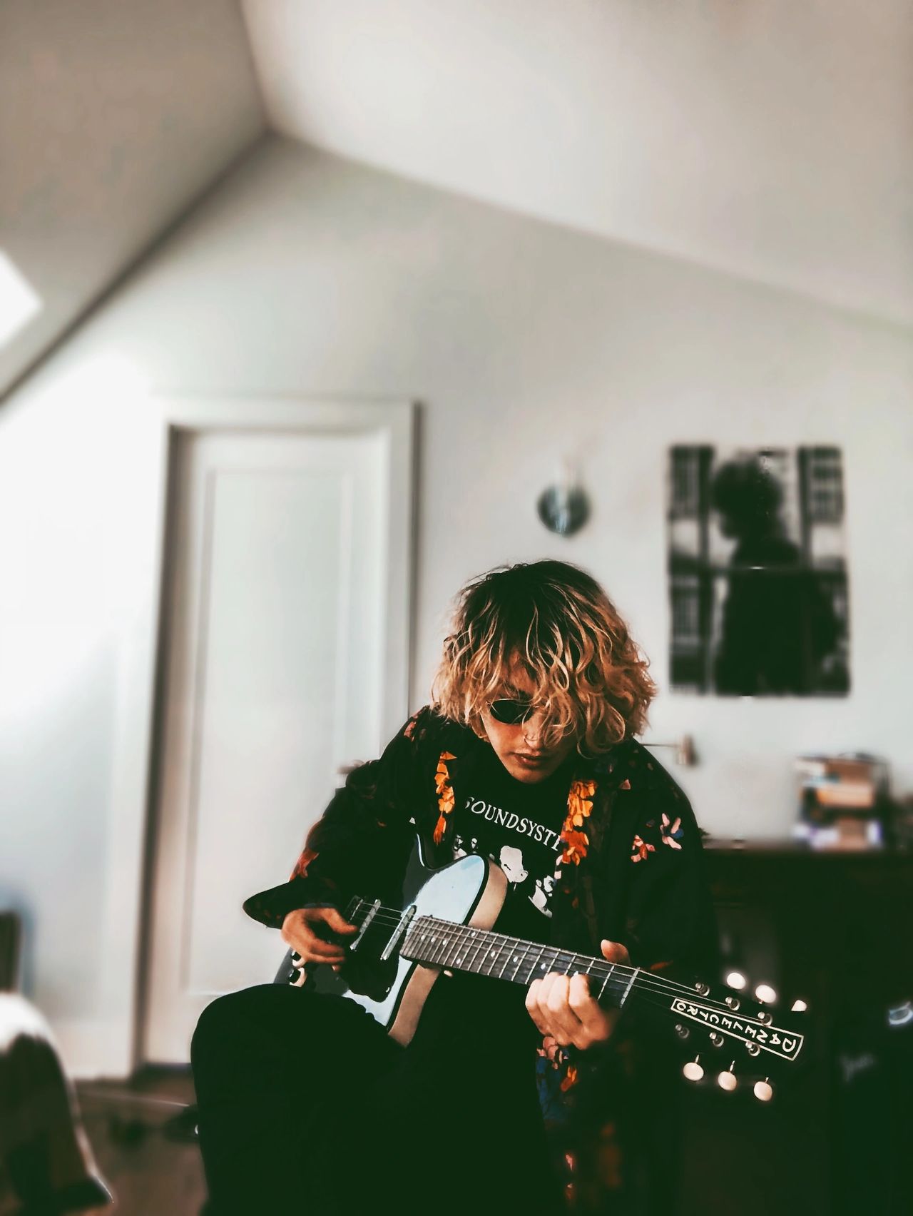man playing electric guitar while sitting down - electric vs. acoustic guitar.jpg