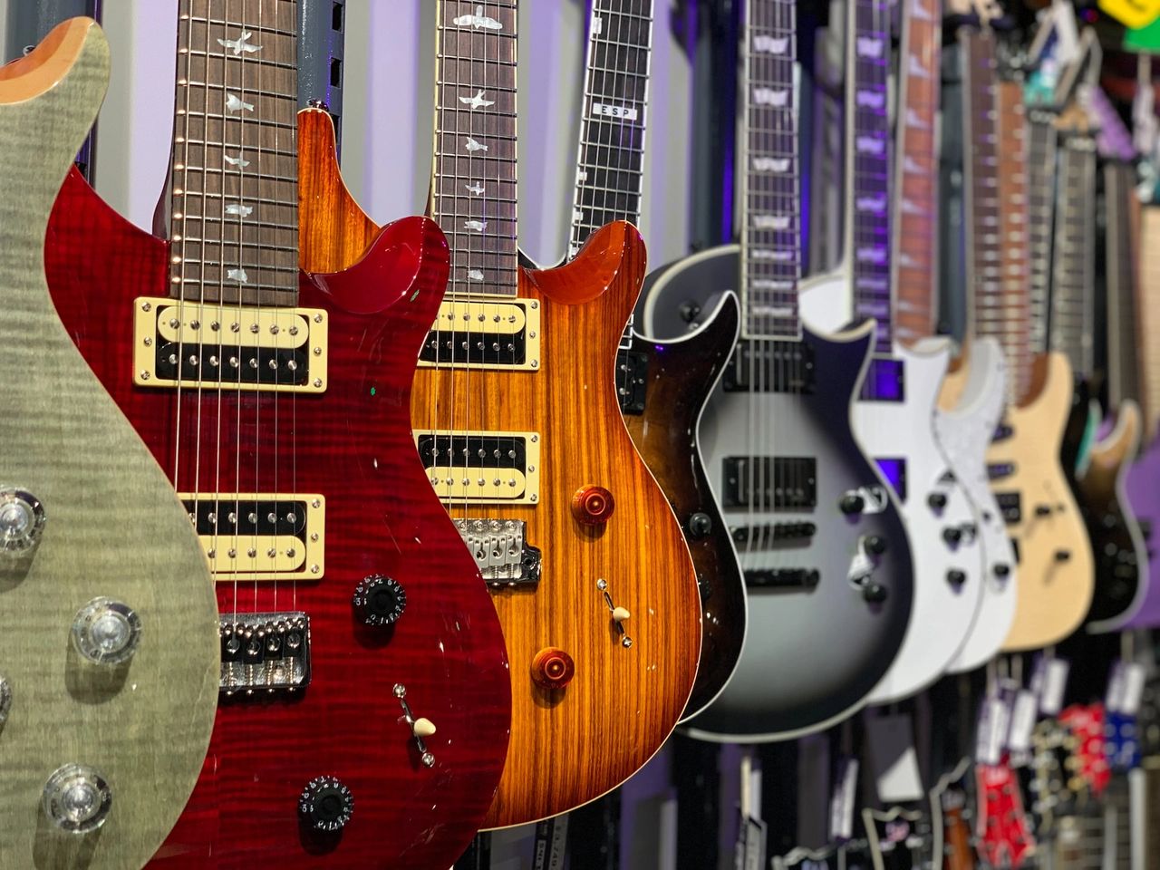 electric guitars on a wall - electric vs. acoustic guitars.jpg